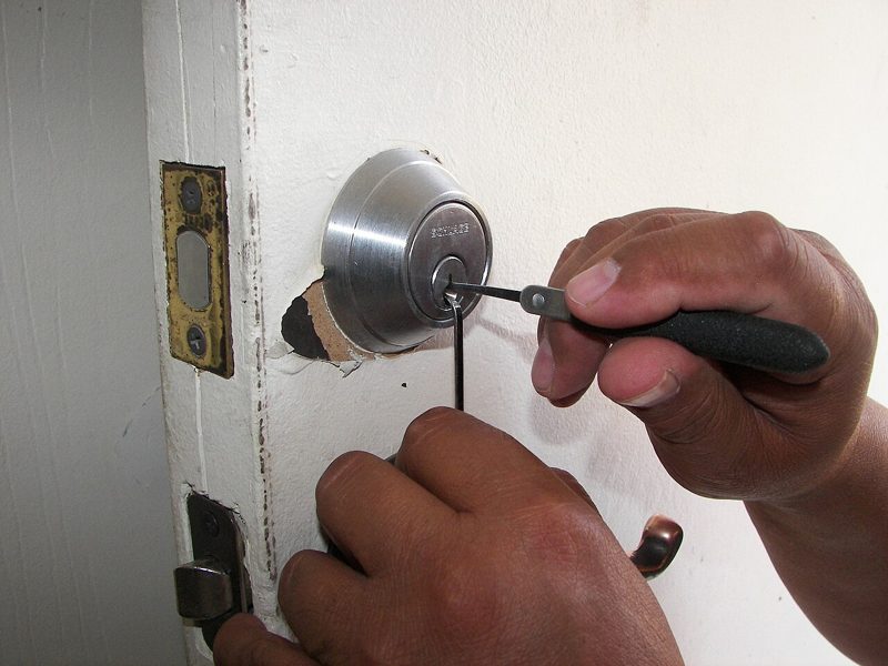 A locksmith fitting a mortice lock into a door